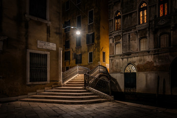 Venedig bei Nacht: eine kleine Steinbrücke unter einem Straßenlicht