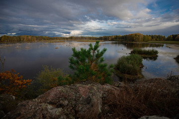 Outlook over a small lake from a hill showing the clear water and cloudy sky above it