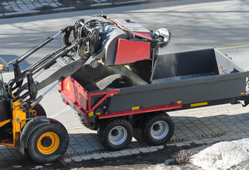 Street cleaning in spring after winter. Collecting gravel from the street in Finland.