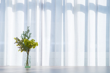 Obraz premium Bouquet in vase decorated near white curtain. Modern lifestyle concept.