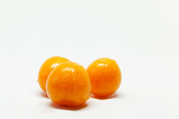three wet physalis fruits on white background