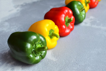Row of multi-colored fresh bell peppers. Green, red and yellow vegetables. Organic healthy food concept