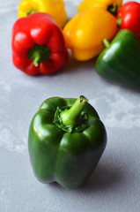 Green fresh uncooked bell pepper with multi-colored sweet peppers. Green, red and yellow vegetables. Healthy food concept
