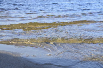 Waves roll on the beach with sand.