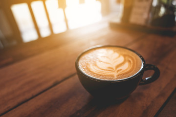 Latte cup on wooden table blur coffee shop background