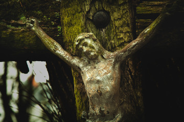 Ancient statue of crucifixion of Jesus Christ on destroyed old wooden cross.