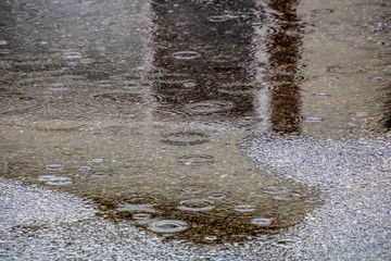 Rain falls on the road and creats puddles. Calgary, Alberta, Canada