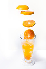 slice oranges, put in a clear glass with fresh orange juice on a white background.