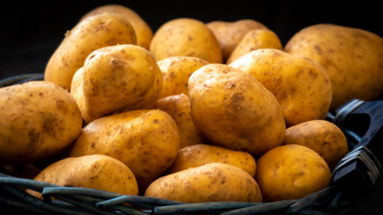 Kartoffeln roh in einem dunklen Weidekorb