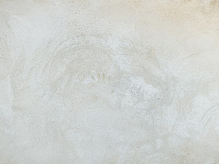 Grey-white concrete wall with many surface shapes due to condensation and splashes.