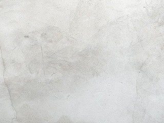 Grey-white concrete wall with many surface shapes due to condensation and splashes.