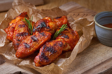 Spicy hot chicken wings cooked with honey and soy, close-up on a rustic wooden background.