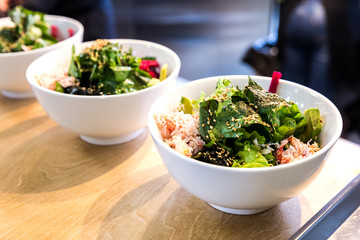 Bowl with vegetables sesame rice and salad in a white bowl