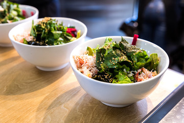 Bowl with vegetables sesame rice and salad in a white bowl