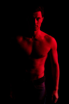 Man in studio with red and blue colors. Look at camera and smile