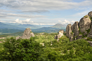 Fototapeta na wymiar Amazing Meteora Monastery in Greece. Fantastic view at mountains and green forest against epic blue sky with clouds. UNESCO