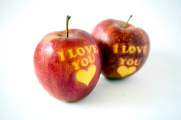 Two red apples with the words I love you