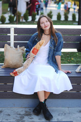 Beautiful girl eat baguette on the street