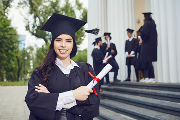 A girl graduate against the background of university graduates.