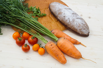 The photo shows farm products, bread, carrots, tomatoes.