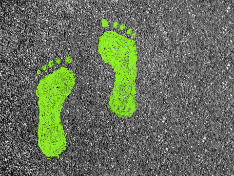 Green footprints on asphalt