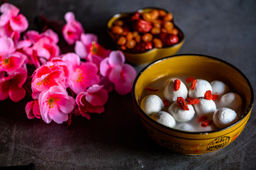 Tangyuan, peanuts, dates, Wolfberry and flowers on the table