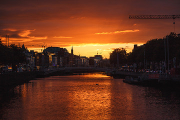 Dublin's cityscape during a colorful sunset with clouds and seagulls over Liffey river