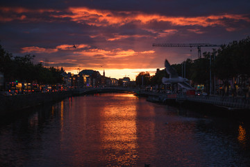 Dublin's cityscape during a colorful sunset with clouds and seagulls