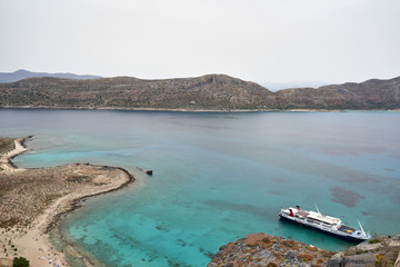 Gramvousa island, Crete, Greece. May 20 2019: ship is staying in the bay near the pirate castle in...