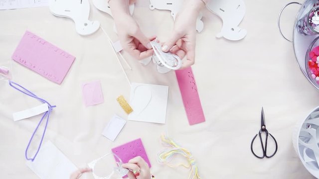 Flat lay. Step by step. Mother and daughter making unicorn craft from paper foam.