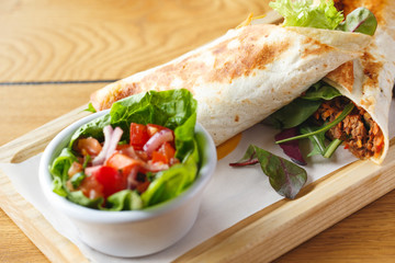 Lunch Time. Burrito and salad isolated on table close-up