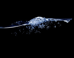 A wave of pure water with bubbles of water and air on a black background.