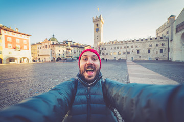happy man tourist take selfie photo in Piazza del Duomo central square in Trento. Trento is a city...