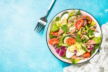 Tuna salad with green leaves, eggs and vegetables.