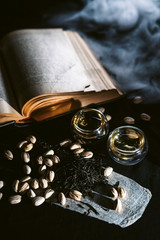 Tea cups at black table with pistachios and old book at background