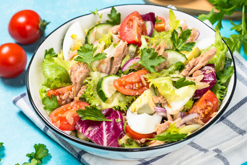 Tuna salad with green leaves, eggs and vegetables.