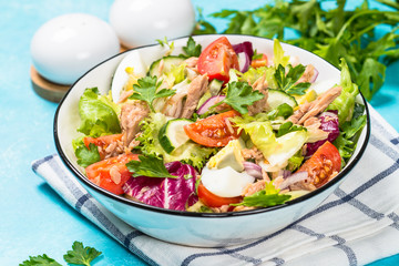 Tuna salad with green leaves, eggs and vegetables.