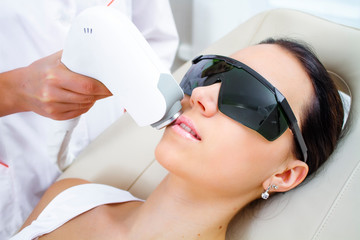 Laser hair removal on a woman's face.