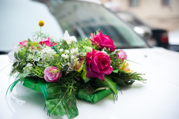 Marriage day composition with pink roses flowers bridal bouquet , wedding flowers viewed from high angle on car background. Burred. Closeup