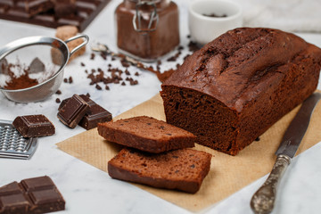 Sliced homemade chocolate banana pound cake loaf. Delicious dessert for Breakfast. A treat for tea. Ingredients on a light wooden table. Selective focus - 321714178