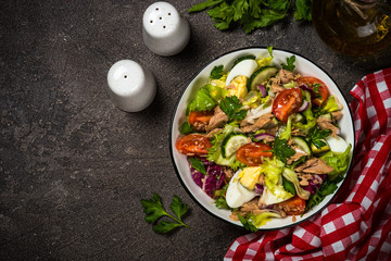 Tuna salad with green leaves, eggs and vegetables.