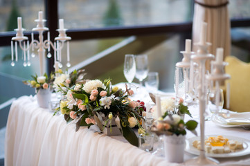 Exquisitely decorated wedding table with bouquet of flowers. Selective focus
