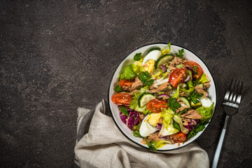 Tuna salad with green leaves, eggs and vegetables.