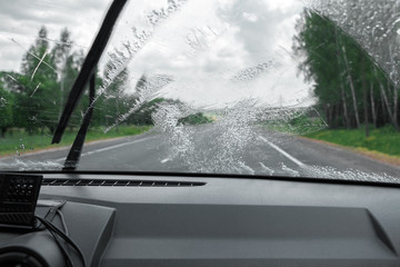 Cleaning the car's windshield with a windscreen wiper - obrazy, fototapety, plakaty