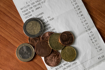 Monedas con ticket de compra y productos y precios