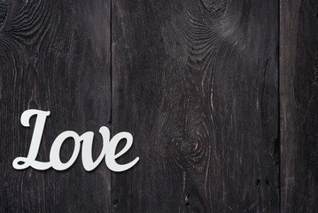 The word "Love" - ​​an article made of wood on a wooden gray background as a concept of love, a symbol.