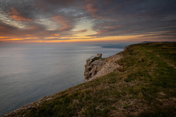 Fototapeta na wymiar Beautiful vibrant sunset over sea and clifftop