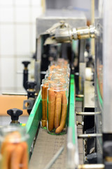 Gläser mit Würstchen auf dem Fliessband in der Produktion im Lebensmittelwerk