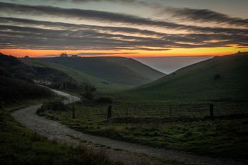 Beautiful vibrant sunset over country road and clifftop