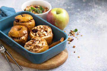 Diet menu. Healthy dessert. Baked apples with walnuts, honey and granola on slate, stone or...